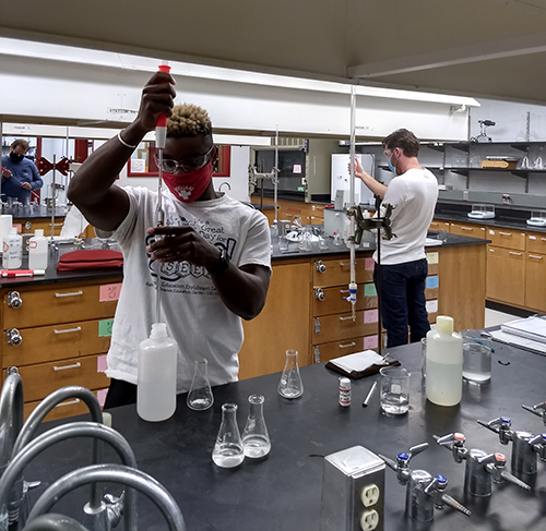Student in lab holding beaker
