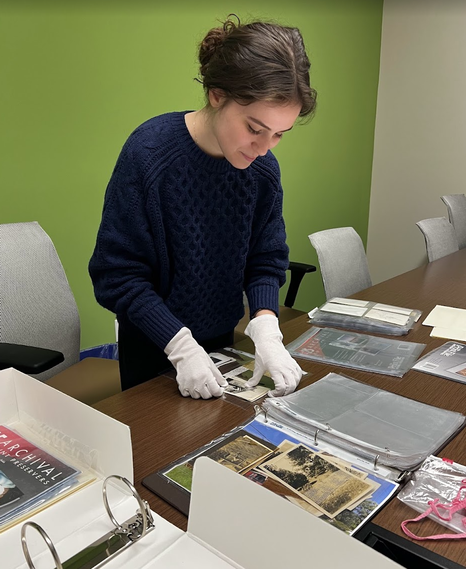 Photo of Addisen Alvanos, preparing a museum exhibit showcased at the Gregg Graniteville Library.