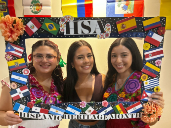 Students posing with a Hispanic Heritage Month poster