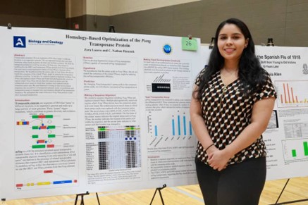 Photo of student with research poster.