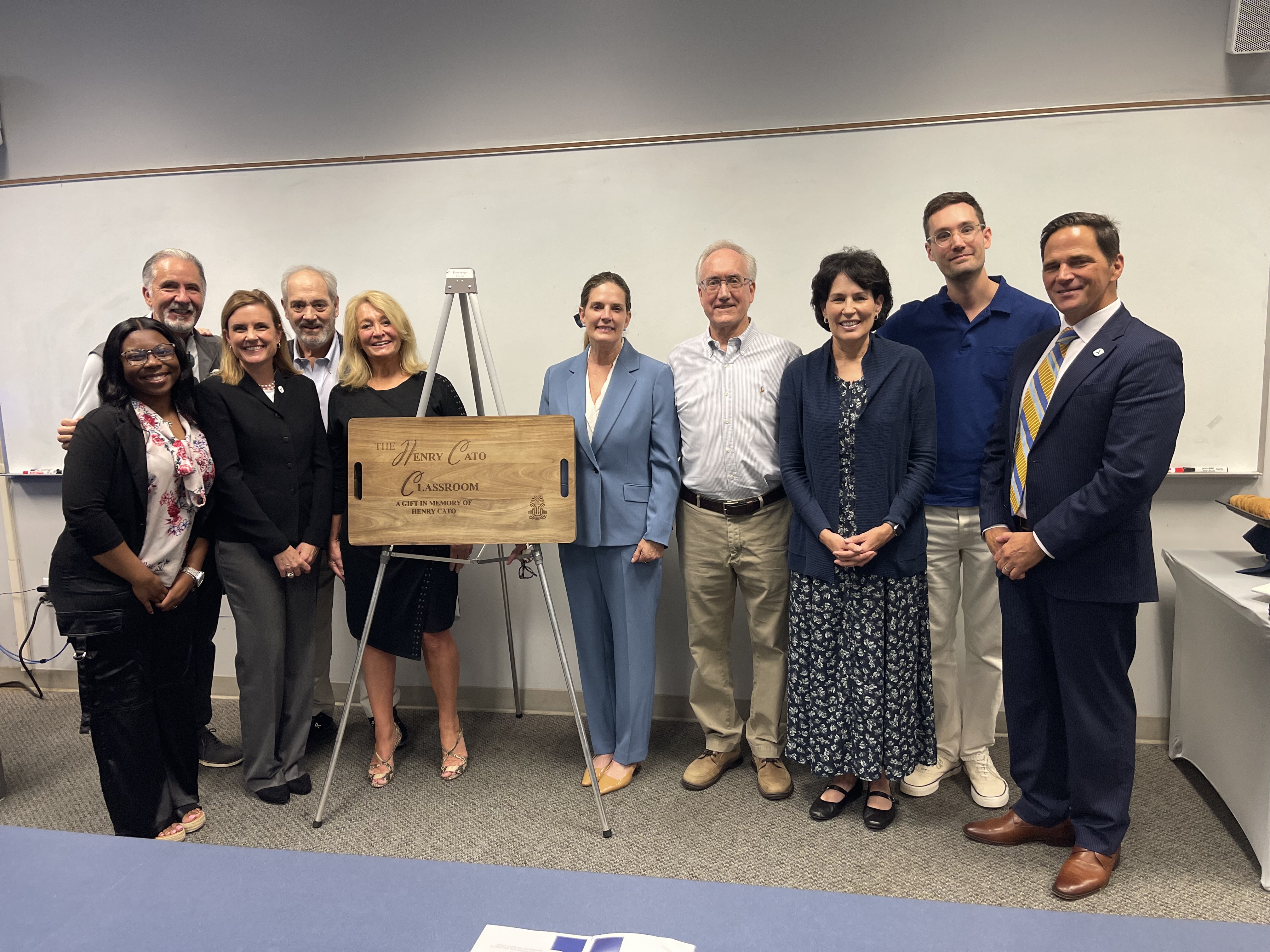 Cato's family and wife, Lisa Cato (in the middle), stand alongside Chancellor Daniel Heimmerman (far right) and student speaker, Justice English (far left).