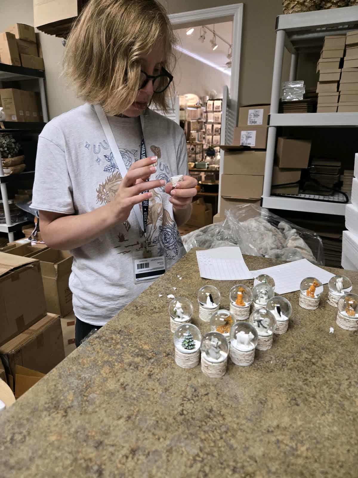 LIFE Student putting price tags on snowglobes